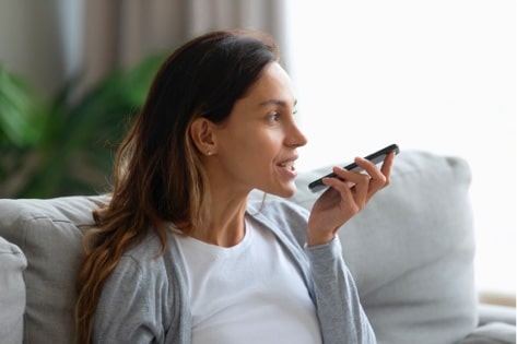 A woman using AI-based voice assistant